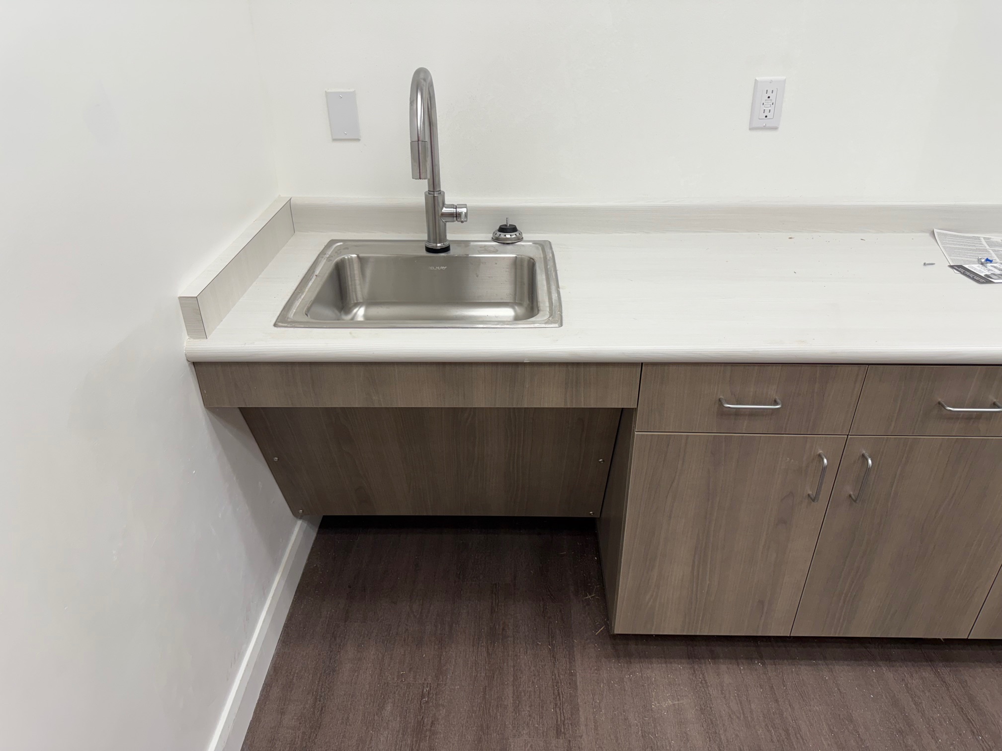 Completed Stantec St. George kitchenette with integrated sink, counter, cabinets and resilient floor