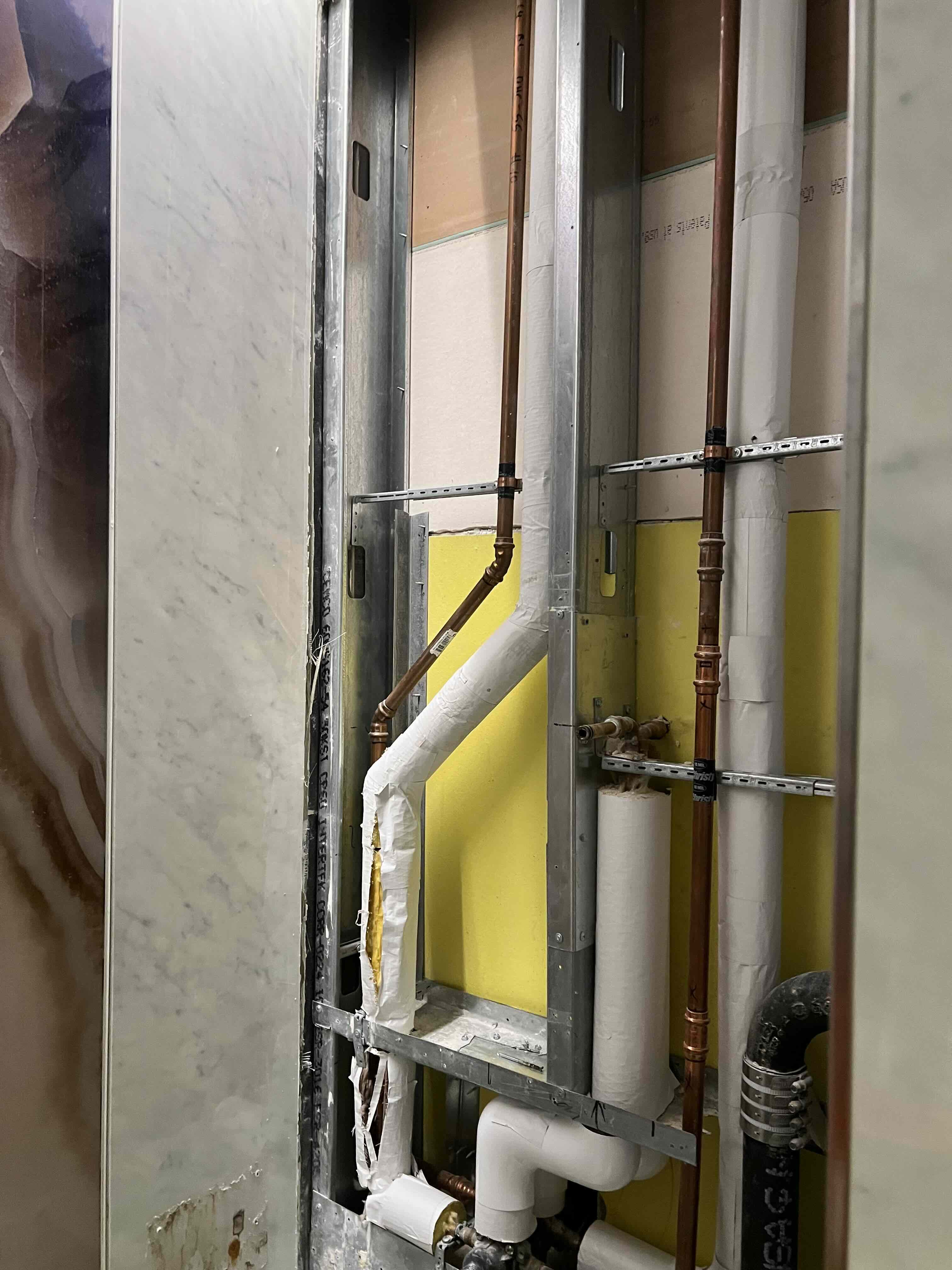 Delta LAX opened shower wall exposing concealed pipework