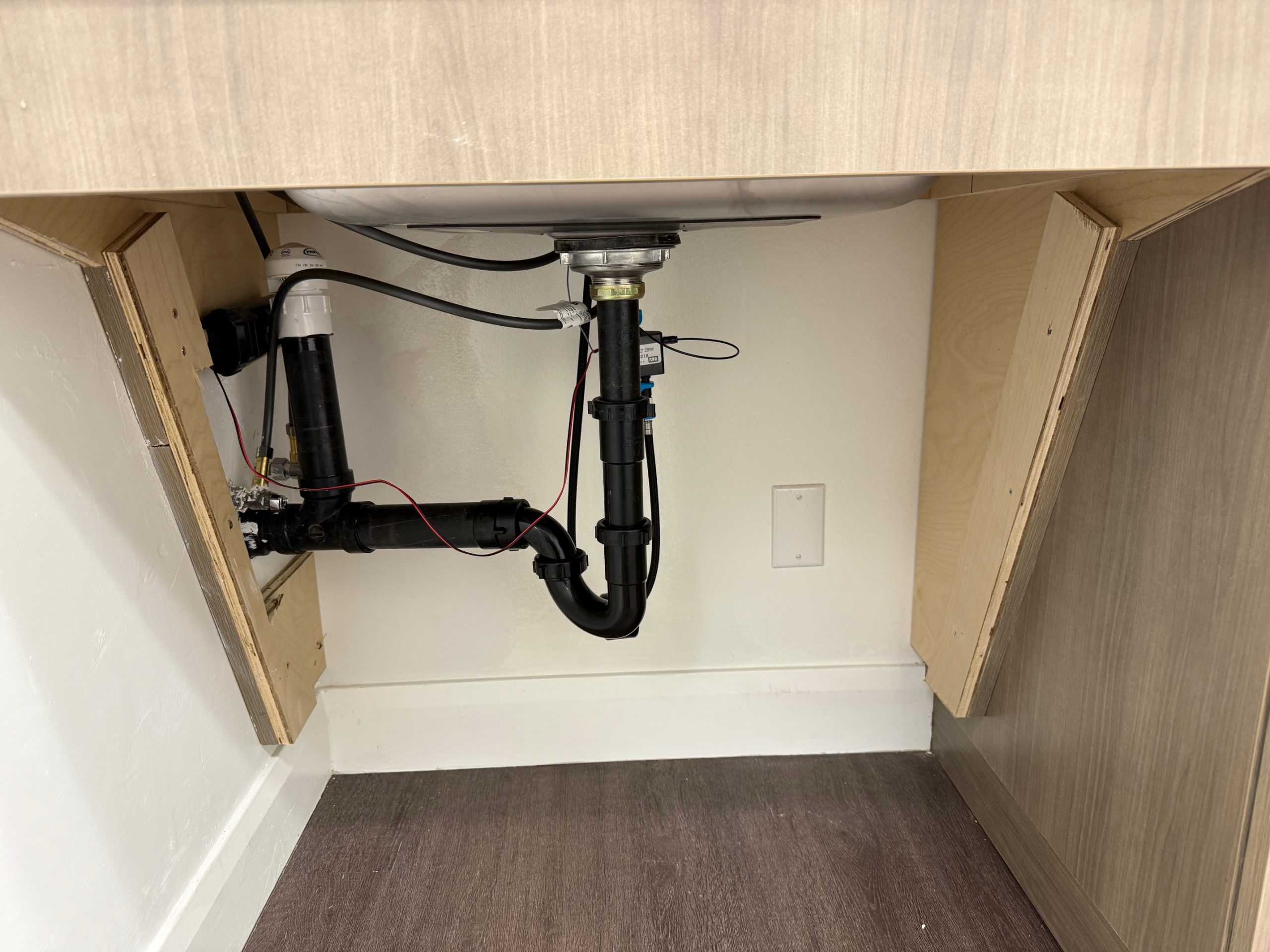 Plumbing beneath Stantec St. George kitchenette sink during renovation
